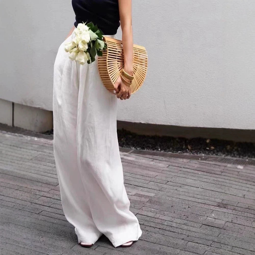 Woman in cotton linen wide leg trousers, high waist and full straight leg drape