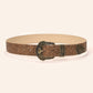 Close view of the ornate antique brass pin buckle on the floral tooled wide belt