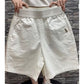 Beige high waist wide leg casual shorts worn at mid thigh length