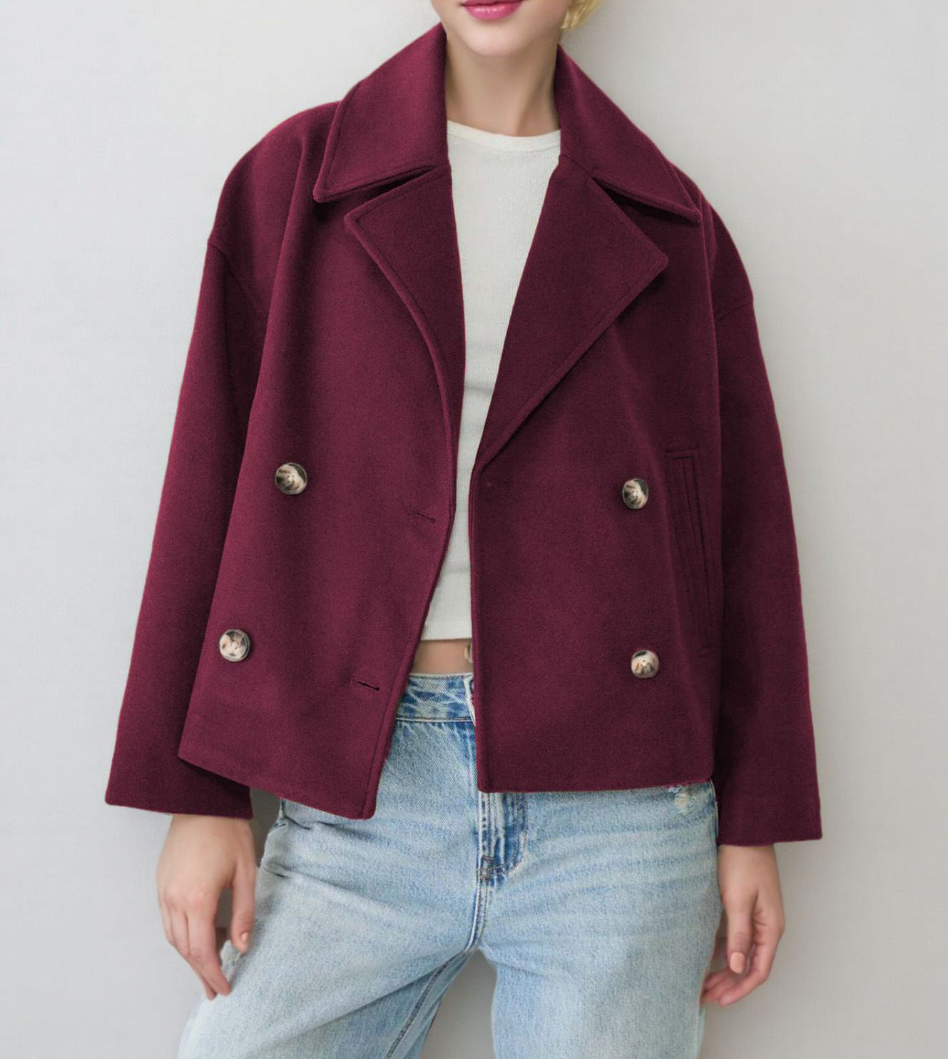 Close view of the notch lapel and double breasted button front of the wool coat