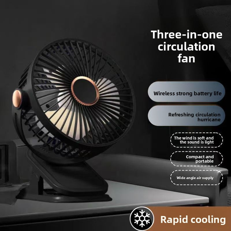 Black clip fan clamped to a dark desk edge, hub light glowing behind the round grille