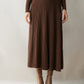 Woman wearing a brown ribbed knit tiered midi skirt with tan ankle boots and a brown knit top