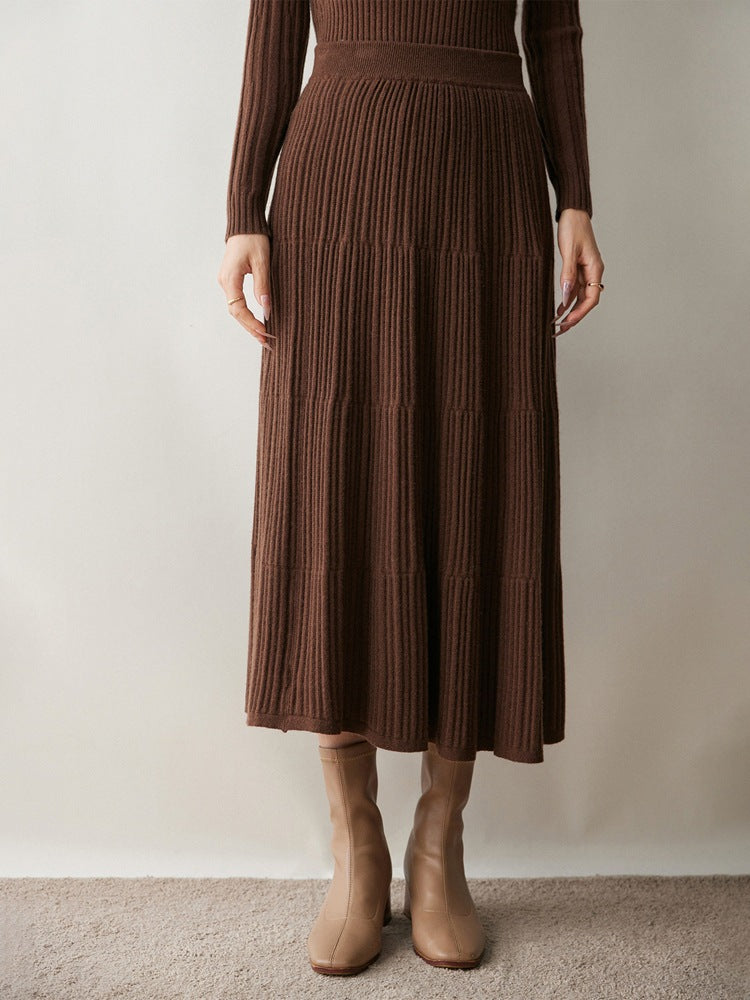 Woman wearing a brown ribbed knit tiered midi skirt with tan ankle boots and a brown knit top