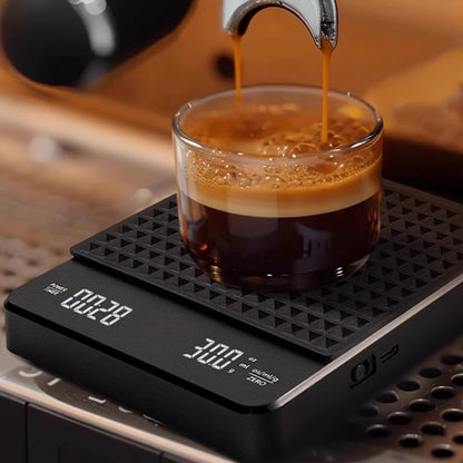 Black digital coffee scale with a textured silicone mat weighing an espresso cup