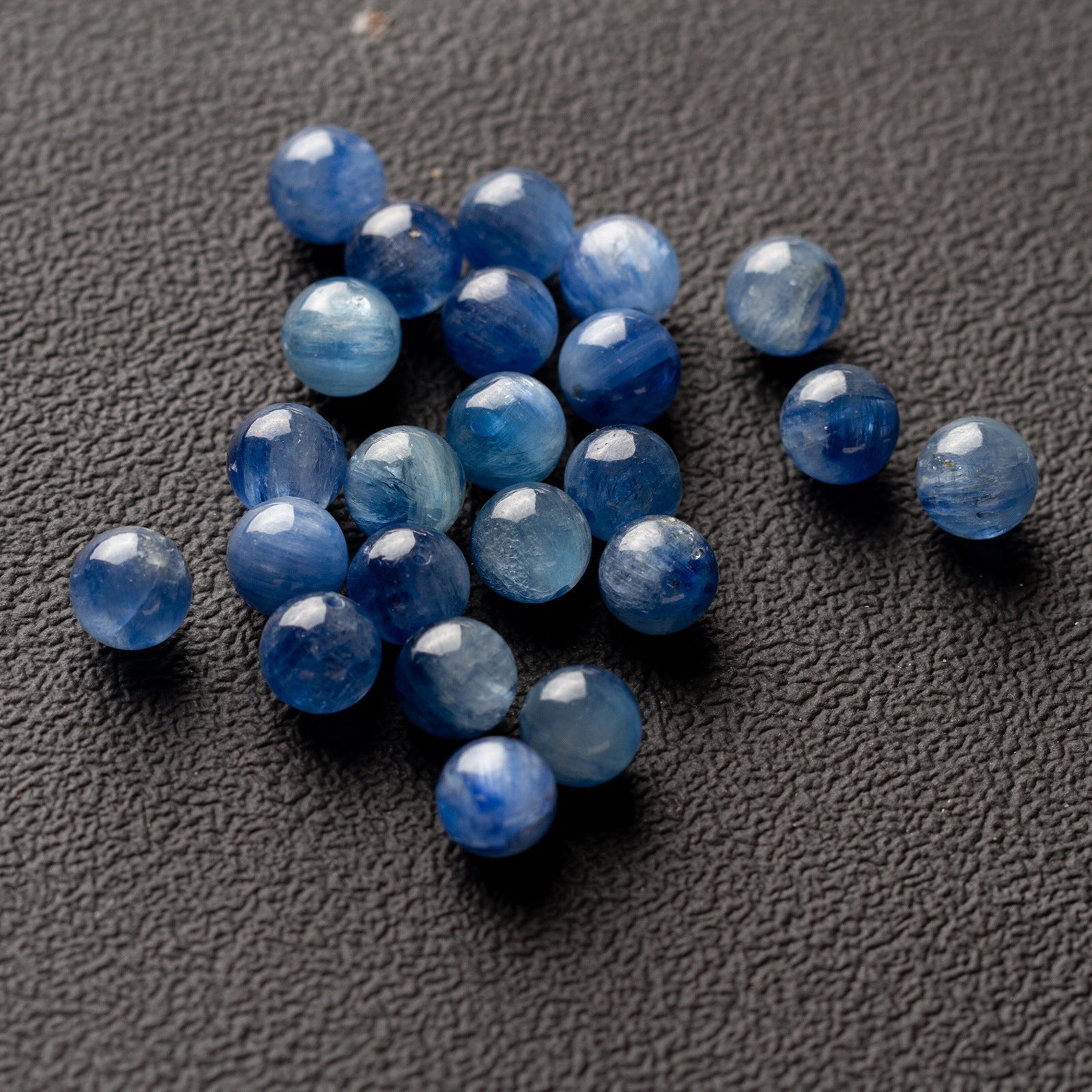 Scattered natural kyanite round beads in shades of blue for DIY jewelry making