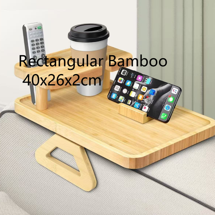 Rectangular bamboo sofa arm tray holding a cup, remote and phone on a sofa arm