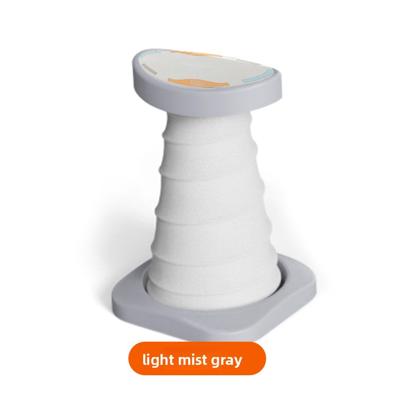 Light mist gray push-up support stand with a ribbed elastic column, curved top pad and gray base plate, light mist gray label