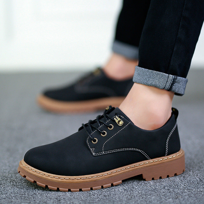 Black low-top lace-up derby shoe with lugged rubber sole worn with rolled jeans, EU 44 option