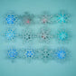 A set of silver glitter snowflake stickers on a teal background with blue and red lit centers