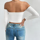 Side view of a white off shoulder long sleeve crop top showing the slim fit and cropped length