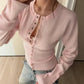 Close view of the buttoned cuff on the long sleeve of the knit cardigan