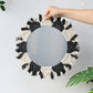 Scale reference of the round boho wall mirror against a plain wall
