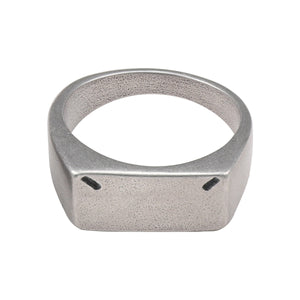 Front view of the matte steel signet ring on white, flat rectangular top with two dark corner notches