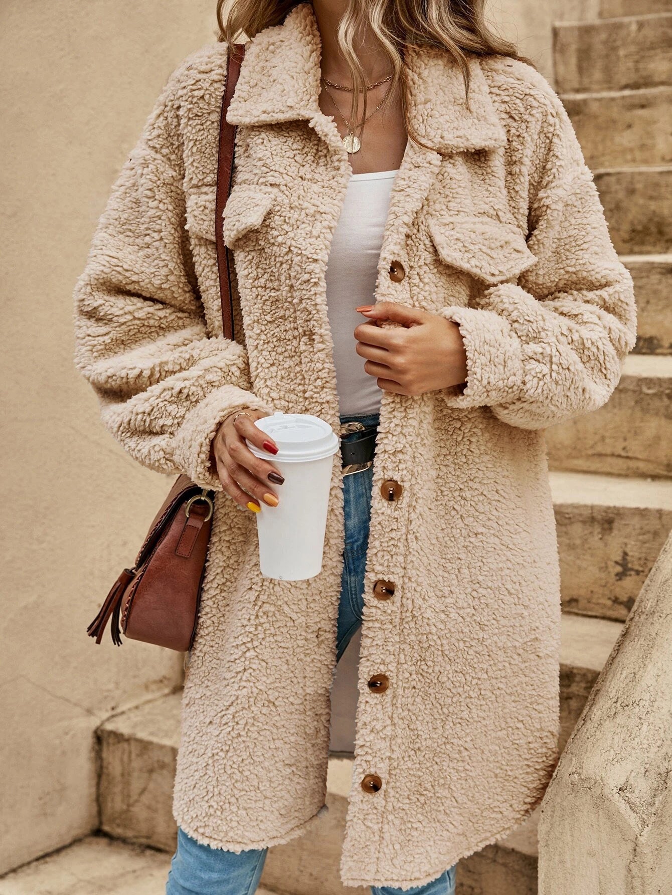 Womens plush fleece button front long coat in brown, worn open over a knit