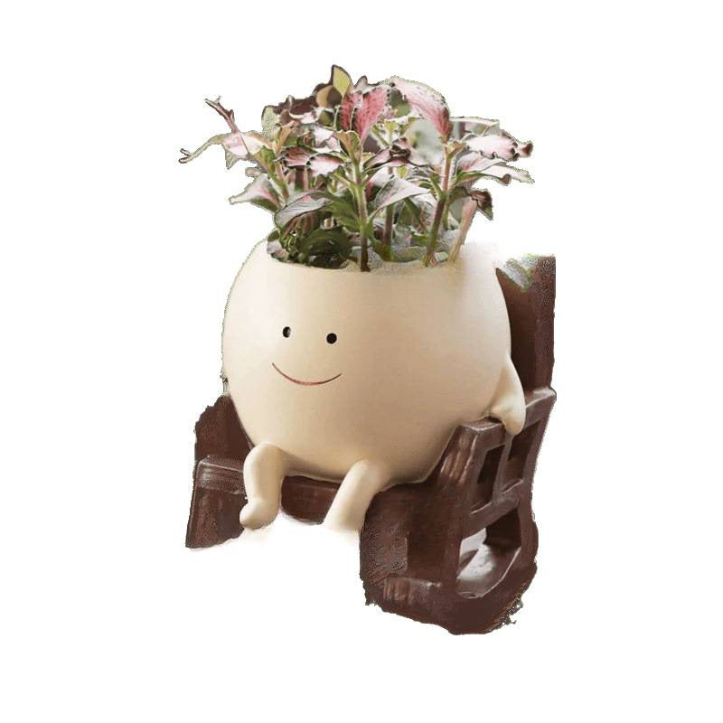 Smiling face rocking chair flowerpot planted with trailing greenery seen from the front
