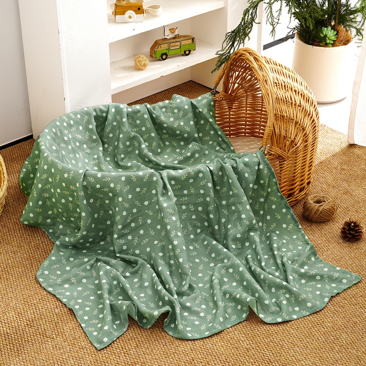 Folded cotton muslin swaddle blanket with a soft open weave and an even printed pattern