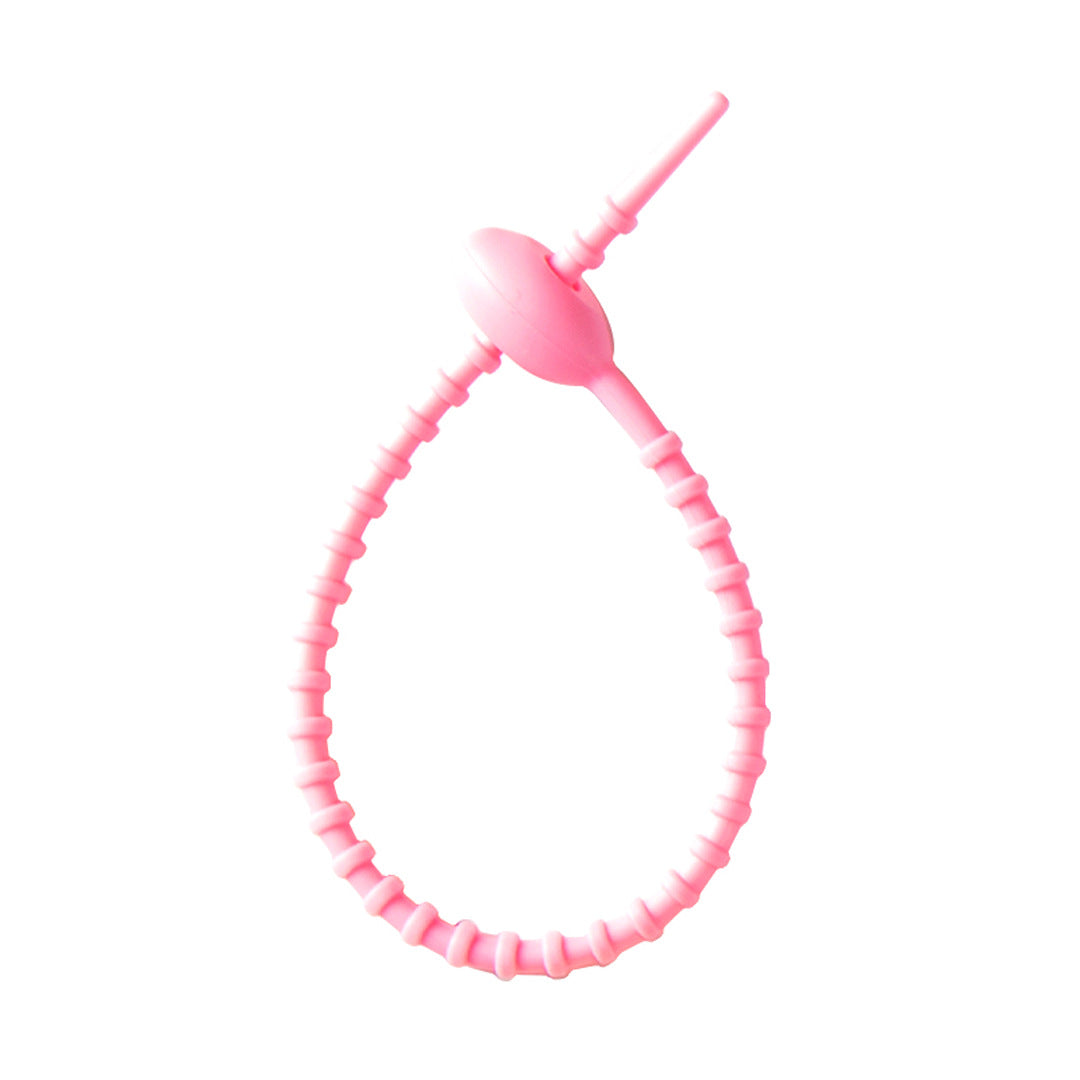 Soft silicone tadpole cable tie coiled into a loop to show the reusable cinch closure