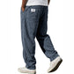 Side view of the loose straight corduroy trousers falling clean over white trainers