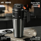 Black double wall insulated stainless steel travel mug standing on a kitchen counter