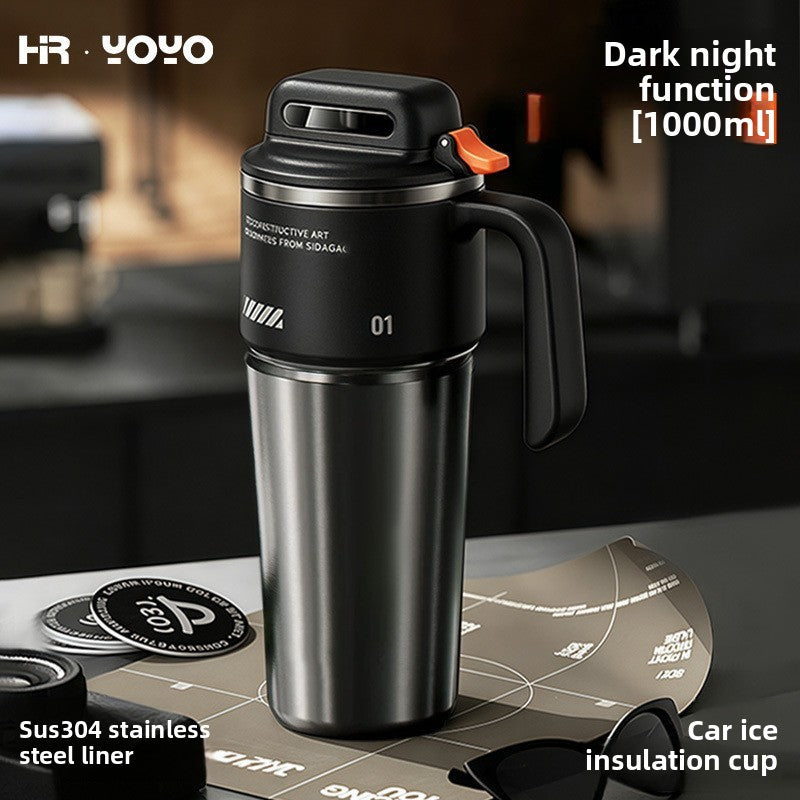 Black double wall insulated stainless steel travel mug standing on a kitchen counter