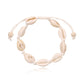 Cowrie shell anklet on a white knotted cord with sliding tie ends and two bone tone beads