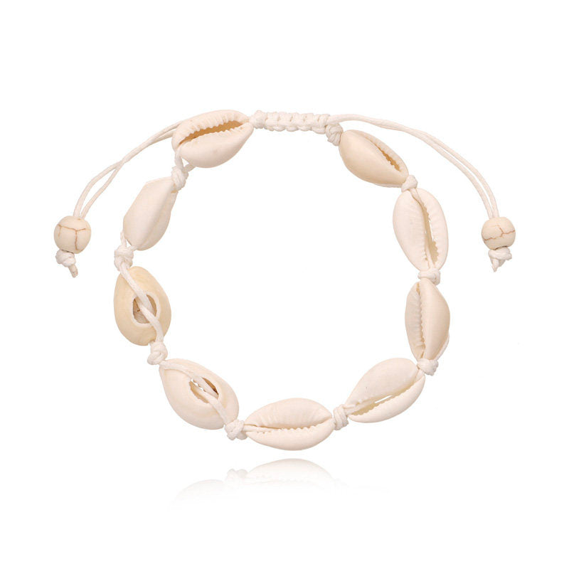 Cowrie shell anklet on a white knotted cord with sliding tie ends and two bone tone beads