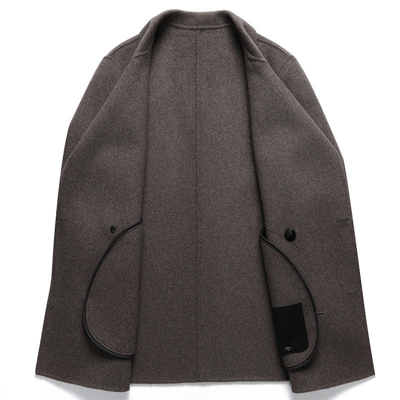 Inside of the camel toned double faced wool overcoat showing stitched edges and welt pockets