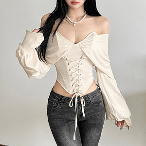 Apricot off-shoulder lace-up top worn front view over grey high waisted jeans