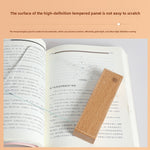 Solid wood reading lamp with a lit glass panel spreading light across an open book