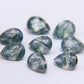 Group of moss agate pears on white, flat crown planes meeting across each polished top