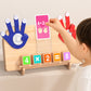 Child placing a pink 4 times 2 card in the holder of a wooden finger math board with number blocks below