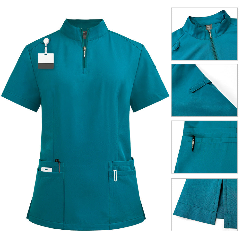 Womens scrub top in sapphire blue shown flat to display the stand collar, quarter zip and hip pockets