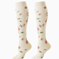 Pair of ivory knee-high compression socks with large pink flowers, green leaves and a yellow heel, size S/M