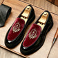 Glossy black loafers with a wine red velvet vamp and an embroidered laurel crest on a wooden table, size 44 option