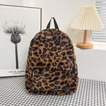 Woman wearing the full size plush leopard print backpack over her shoulders