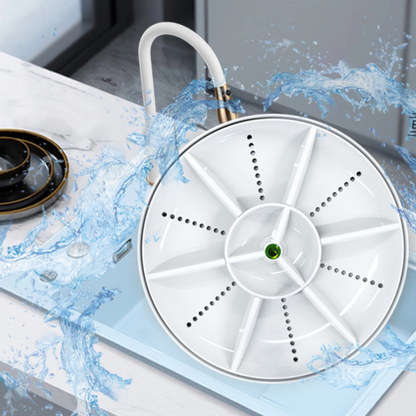 White round vortex dishwasher disc with a green gem in a kitchen sink under a faucet with splashing water
