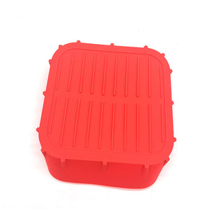 Grey silicone air fryer liner sitting inside a square air fryer basket with food