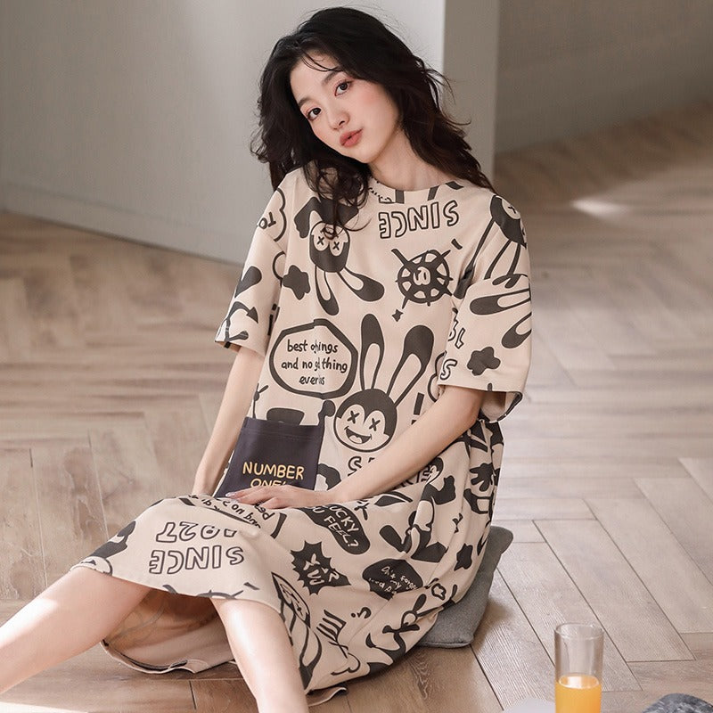 Woman on a cushion in a beige short sleeve nightgown with a black rabbit print and lettering, view 6 of 7