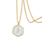 Close view of the pale blue swirled enamel cross pendant, gold plated bail and irregular hexagon edge visible