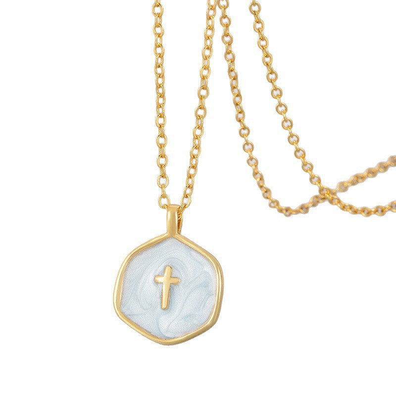 Close view of the pale blue swirled enamel cross pendant, gold plated bail and irregular hexagon edge visible