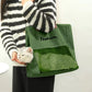 Olive green cat carrier tote with a cat resting its head out the side opening