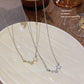 Silver tone star cluster necklace resting across the fingers of a hand