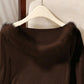Brown ribbed top on a hanger showing the fluffy off-shoulder neckline trim up close