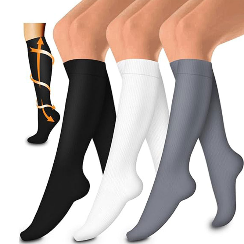 Three knee-high compression socks in solid black, white and grey with fit arrows