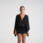 Angled view of the V-neck mini dress styled for a casual day out