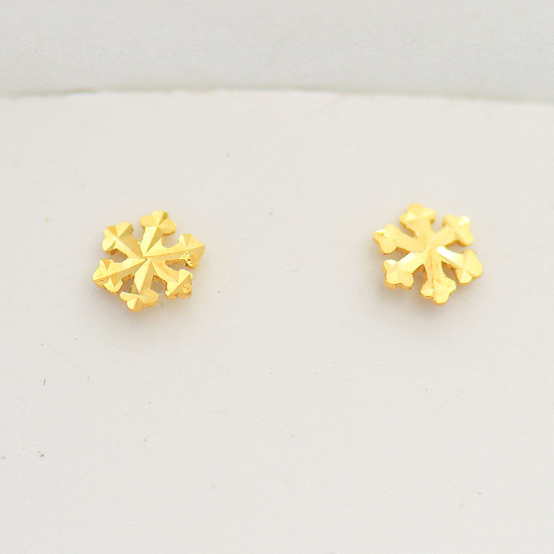 Top down layout of both mini snowflake floral gold stud earrings side by side