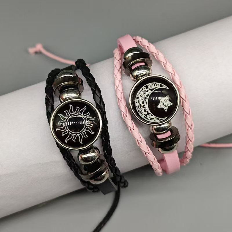 Black sun and pink moon cord bracelets on a display roll showing the sliding knot cord fasteners