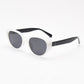 White frame with black temples and grey tinted polarized lenses at an angle