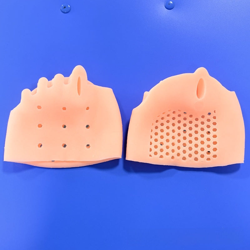 Nude forefoot cushion pad held in a hand to show its soft stretchy SEBS body