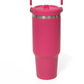Hot pink insulated tumbler with a stainless steel ring below the flip lid and a handle at the top